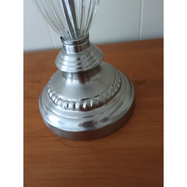 Bring a touch of modern elegance to your space with this beautifully crafted silver and ribbed‑glass table lamp. The base...