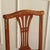 A stylish antique chair from the late 19th to early 20th century featuring an open-work backrest, a wicker seat, and...