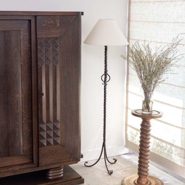 Lovely black iron floor lamp from France, 1940s. Twisted iron stem on three curved iron legs with loop detail. New paper...