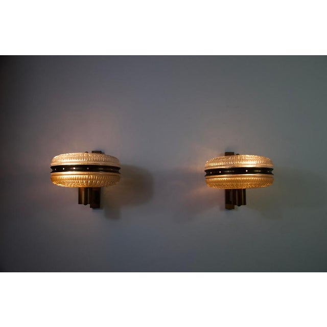 This elegant pair of italian wall lamps from the 1960s beautifully captures the refined materiality and balanced...