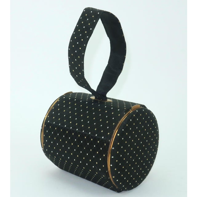 1940's Lin Bren compact handbag in a barrel shape designed with gold tone metal and black satin fabric accented by a gold...