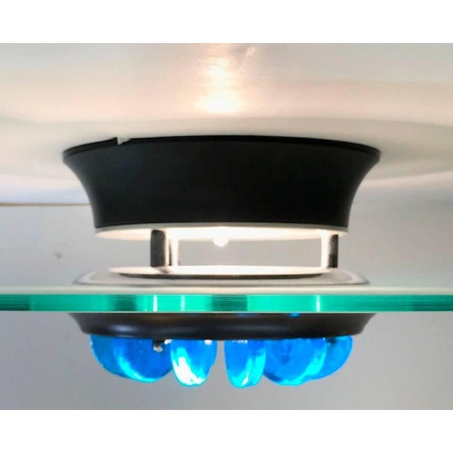 An Italian 1980s Italian ceiling mount light in the Memphis style. 24" reversed frosted glass dish, black enamel mount,...