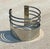 This vintage silver minimalist adjustable cuff bracelet is a study in understated elegance. Defined by clean lines, a...
