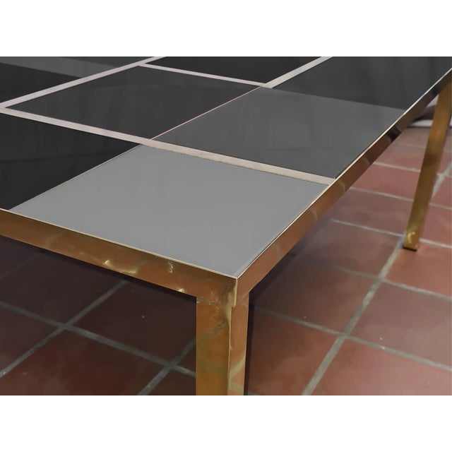 This square coffee table features a stunning gray and black Murano glass top, elegantly set in a durable brass frame....