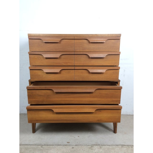 This mid century modern highboy dresser by Johnson Carper features hardwood construction, original walnut finish, five...