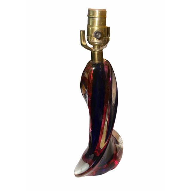 A sculptural mid-20th-century Belgian art glass table lamp attributed to Val Saint Lambert, distinguished by its elegant...
