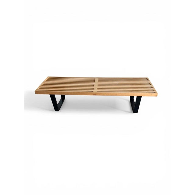 Authentic Herman Miller slatted bench crafted in solid maple with a black geometric base. A clean, architectural piece...