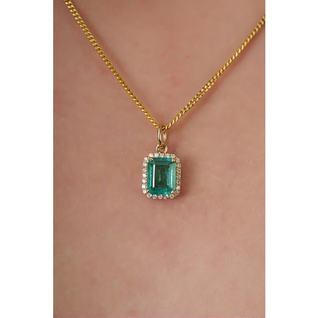 This elegant pendant features a vibrant 1.55 caratCrafted in 14K yellow gold, The emerald measuring 8 x 6 mm, secured in a...