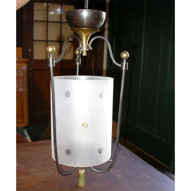 Cylindrical etched glass, wrought iron lantern with bronze trim.