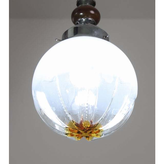 Mazzega chandeliers made in the 1970s by Carlo Nason. An elegant designer light made of white glass, wood and metal frame...