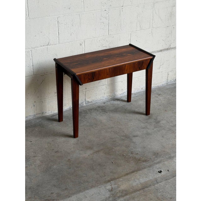 This beautiful accent table features a minimalist rectangular top paired with elegant tapered legs. A single wide...
