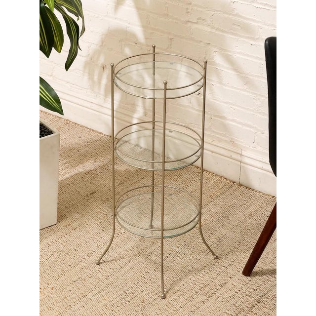 A wonderfully sculptural vintage side table featuring a slender metal framework designed to hold three graduated round...