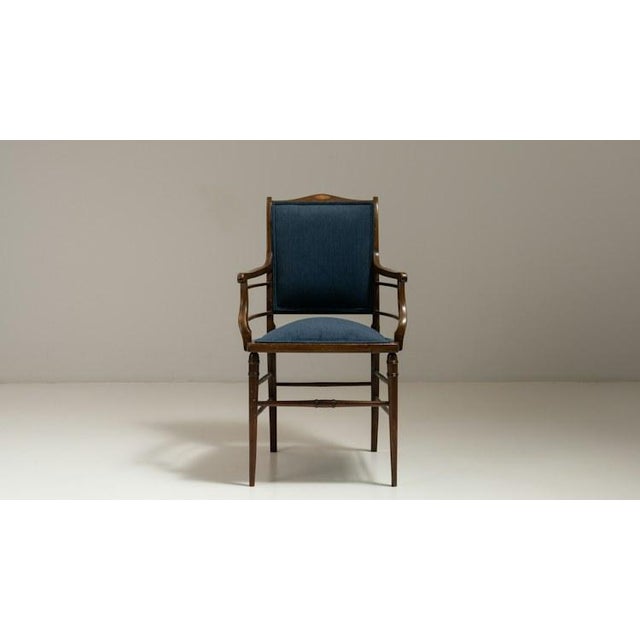 Made in England in the 19th century, this armchair pairs a dark, richly polished wood frame with a deep navy upholstered...