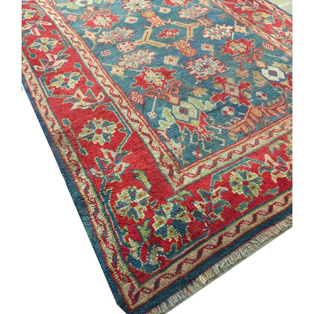 This antique Turkish Oushak rug, hand-knotted and dating back to circa 1890, features central floral motifs highlighted...