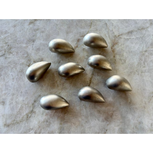A set of 8 mid century cabinet knobs. Made out of a heavy metal with a brushed nickel type finish. No screws included.