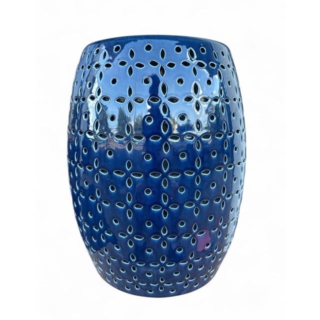 The Lovell Garden Stool is a ceramic garden stool with a barrel form and a delicate petal-flower pierced pattern in a...