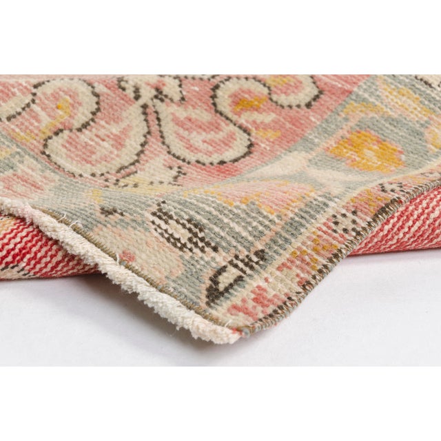 This is a vintage Turkish Oushak rug from the Mid 20th Century. The piece was hand-knotted.