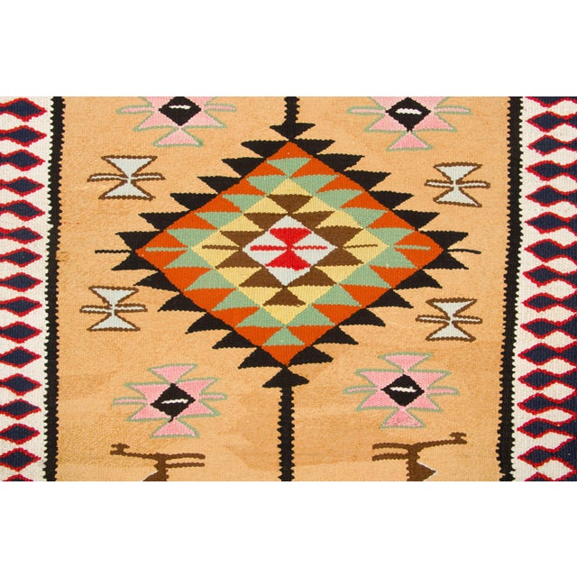Hand-knotted in wool, originating circa 1950-1959, this 3x11 vintage Turkish runner features a warm beige field adorned...
