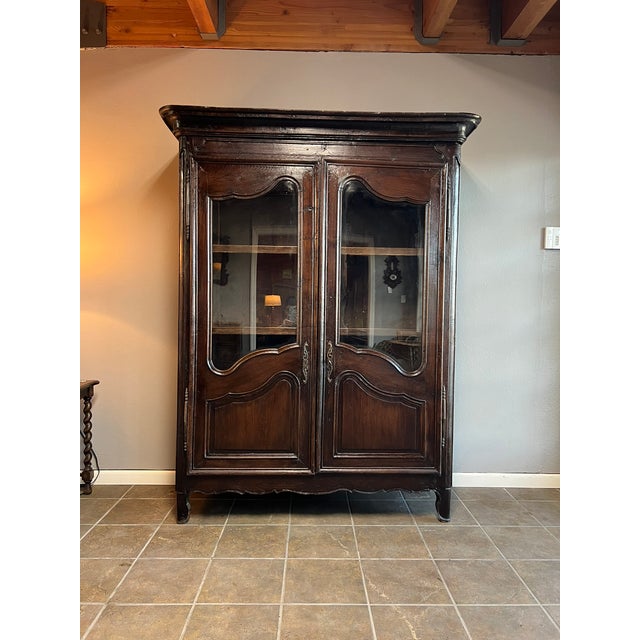 Crafted circa 1830, this solid oak French display cabinet features dowel joinery—free of screws—revealing its pre-...