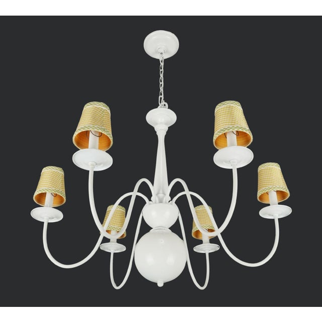 Cottage style chandelier made of a white steel frame with six arms, each topped with yellow and green checkered fabric...