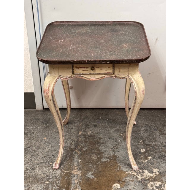 Design Plus Gallery presents a Swedish Faux Porphyry Top Side Table + Drawer. The table has a mottled tray style top with...