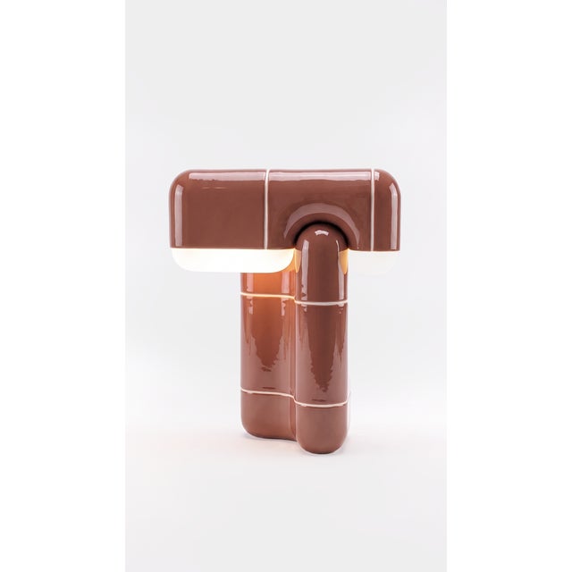 A table lamp that behaves like sculpture. Its folded, tile-built form reads as one continuous gesture, and when the light...