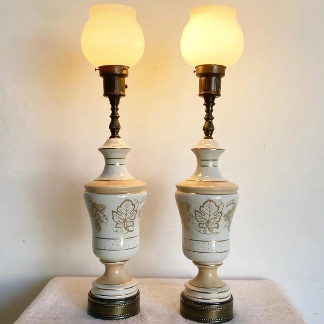 Wonderful pair of vintage mid century table lamps. Each feature a hand painted porcelain body with glass lamp shades.