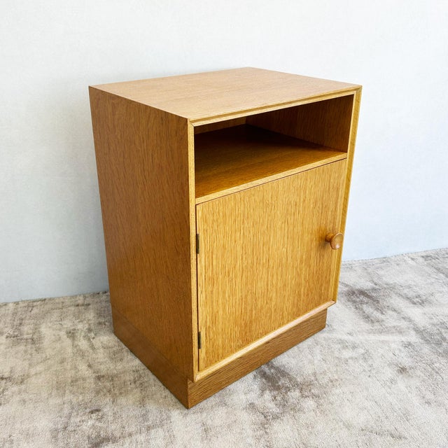 Pair of oak bedside cabinets by Meredew from the 1960s, each featuring open shelf above a lower cupboard with round solid...