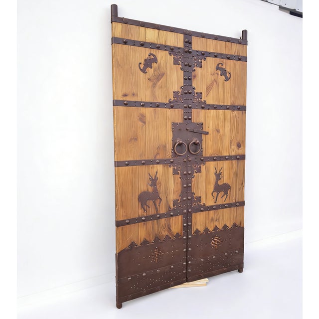This pair of 19th century Chinese door panels showcase a masterful blend of rustic wood and hand-forged ironwork. With...