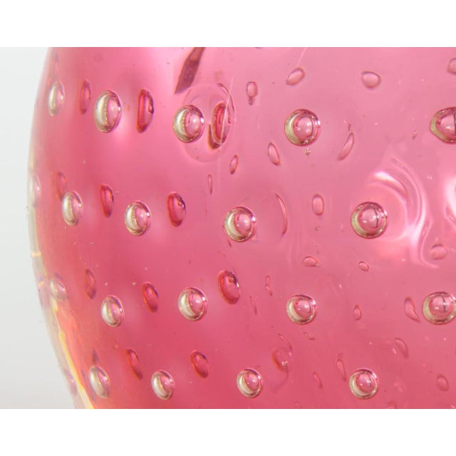 A scarce small, but weighty, globe-shaped sommerso glass table lamp, with a core of pink, a layer of controlled bubbles...