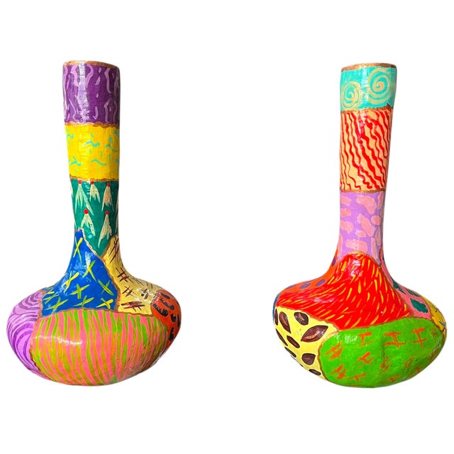 A striking pair of handmade papier-mâché vases featuring bold, patchwork-style decoration in saturated, high-contrast...