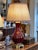Elegant table lamp with a bulbous ceramic body in a deep sang de boeuf glaze, set on a brass footed base with laurel...