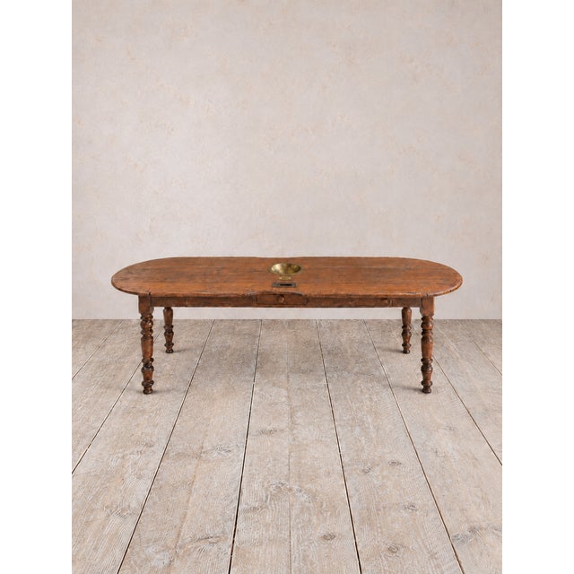 A distinctive antique European country walnut table with a beautifully worn surface and unexpected details. The elongated...