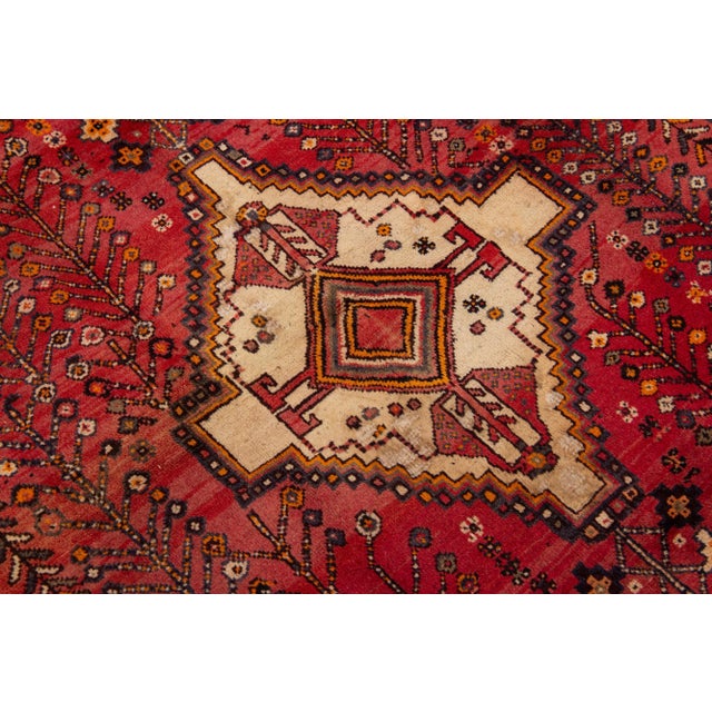 Beautiful vintage Persian Shiraz hand-knotted wool rug with a red field. This piece has multicolor accents in an all-over...