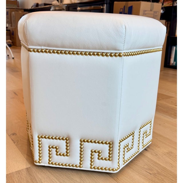 Elegant Ethan Allen hexagon ottoman upholstered in white leather with distinctive antique brass nailhead trim. The design...