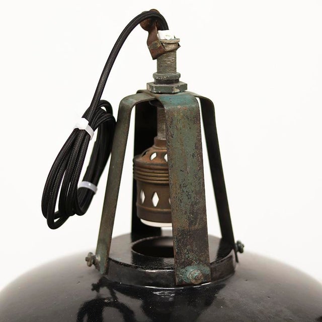 Set of two industrial factory lamps. The lamps have an enamel black shade and have acquired an extremely decorative patina...