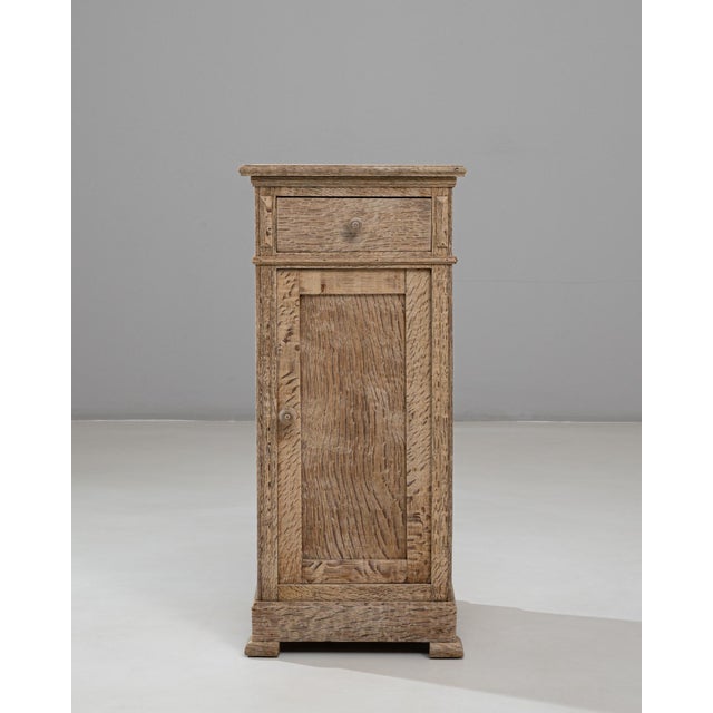 This 1900s French oak bedside table presents a simple, rustic elegance rooted in traditional craftsmanship. Built from...