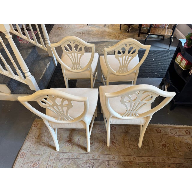 This is a set of four antique Mahogany Hepplewhite style Shield back chairs. They are hand painted French linen white....