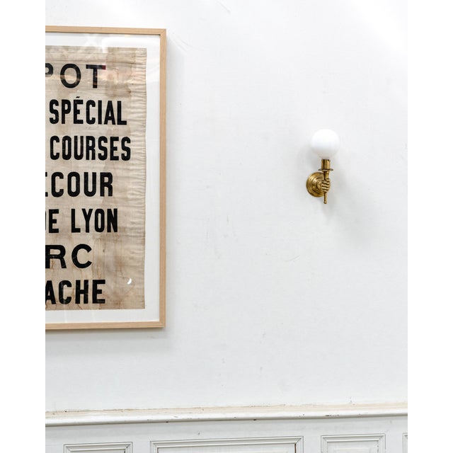 An elegant pair of Maison Jansen wall sconces from the 1950s, crafted from gilt brass and opaline glass. Their design,...