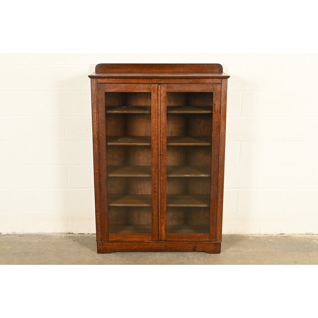 A beautiful antique Mission or Arts & Crafts period glass front bookcase or display cabinet In the manner of Charles P....