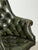 Elegant vintage swivel director’s chair in the classic Chesterfield style, upholstered in deep green button-tufted leather...