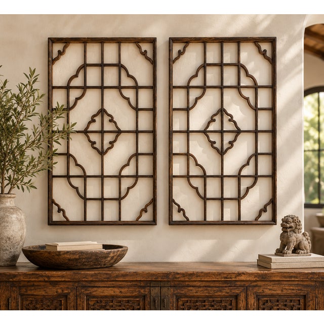 Two tall lattice panels, each a grid of slender wooden bars with a cloud-shaped medallion at the center and curled ruyi...