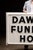 A large-scale vintage commercial sign panel displaying the words “DAWSON FUNERAL HOME” in bold, raised black lettering....