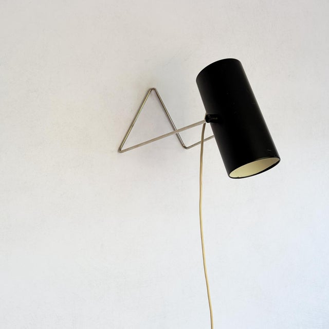 A dual-purpose lamp of minimal wire-and-cylinder construction. The frame is formed from a single length of chromed steel...
