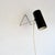 A dual-purpose lamp of minimal wire-and-cylinder construction. The frame is formed from a single length of chromed steel...