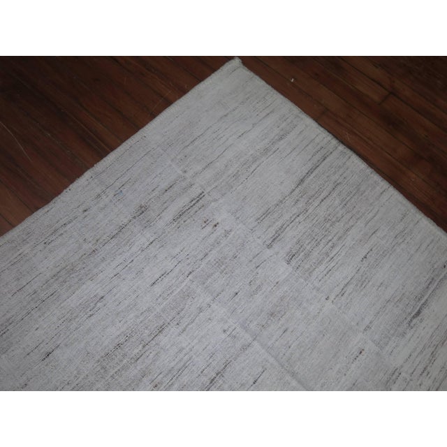 Room size Turkish Kilim, ivory and specs in brown, gray and small re-weave on one end in a bone color. Made from recycled...