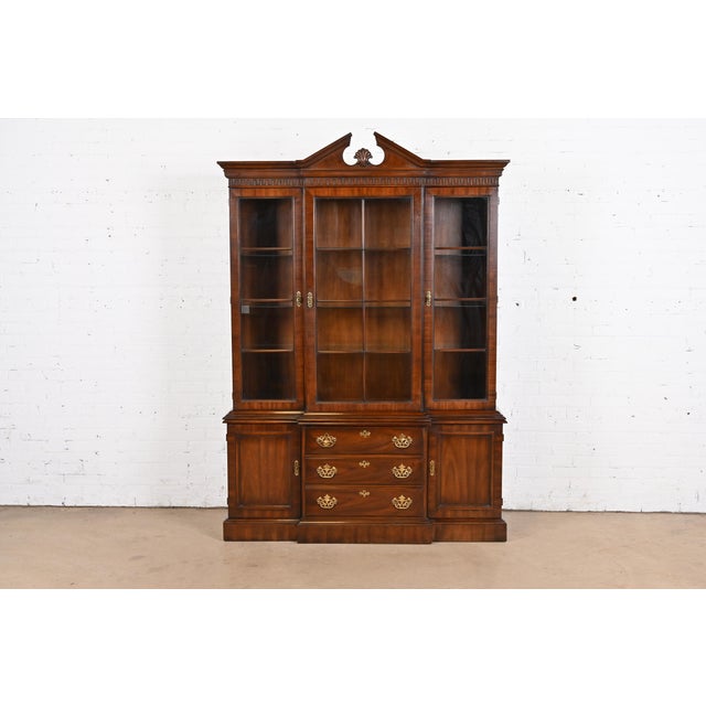 A gorgeous Georgian or Chippendale style lighted breakfront bookcase or dining cabinet By Drexel Heritage USA, Circa 1970s...