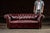 Mid-20th Century; Origin Unmarked (English Style) Classic three-seat Chesterfield sofa upholstered in deeply patinated...