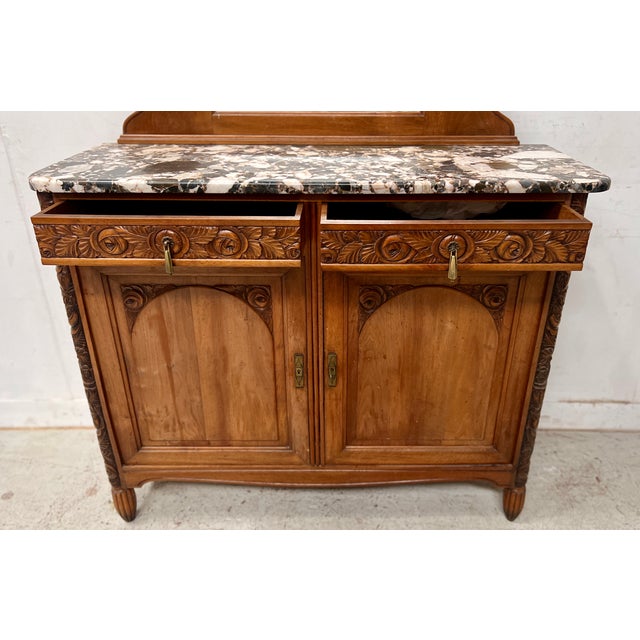 Art Deco period buffett in solid walnut Two rounded uprights carved with floral decoration Two doors and two drawers...