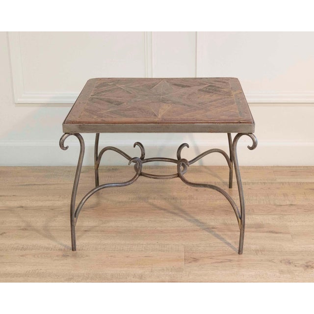 A distinctive French coffee table from the 1980s featuring a decorative parquet top arranged in an “Old Wind Rose”...